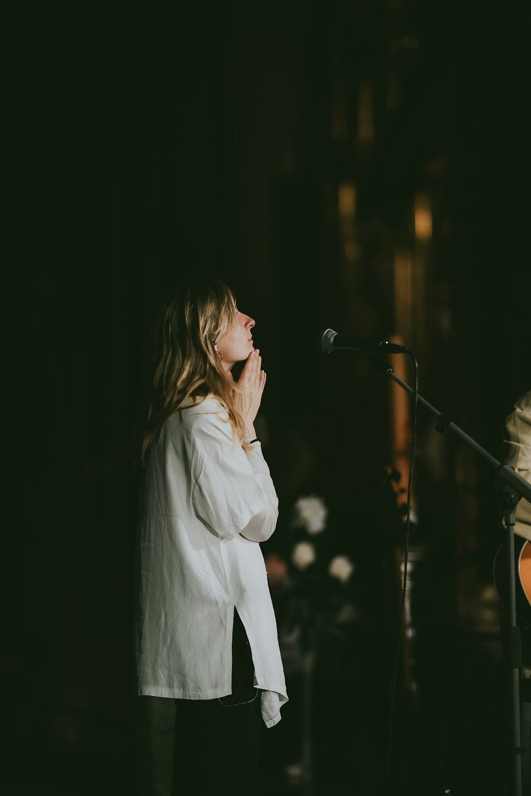 Woman interviewing a guest on stage with microphones